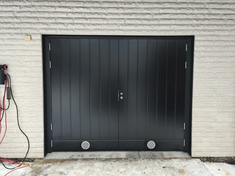 Uusi musta pystyuritettu autotallin pariovi peltipieleillä asennettuna Lahdessa