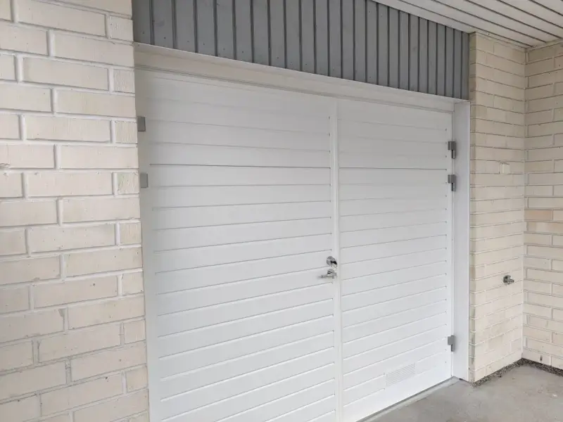 Valkoinen autotallin pariovi Abloy-lukituksella