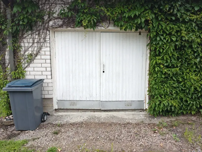 Vanha vuotava autotallin pariovi ennen vaihtoa Porvoossa