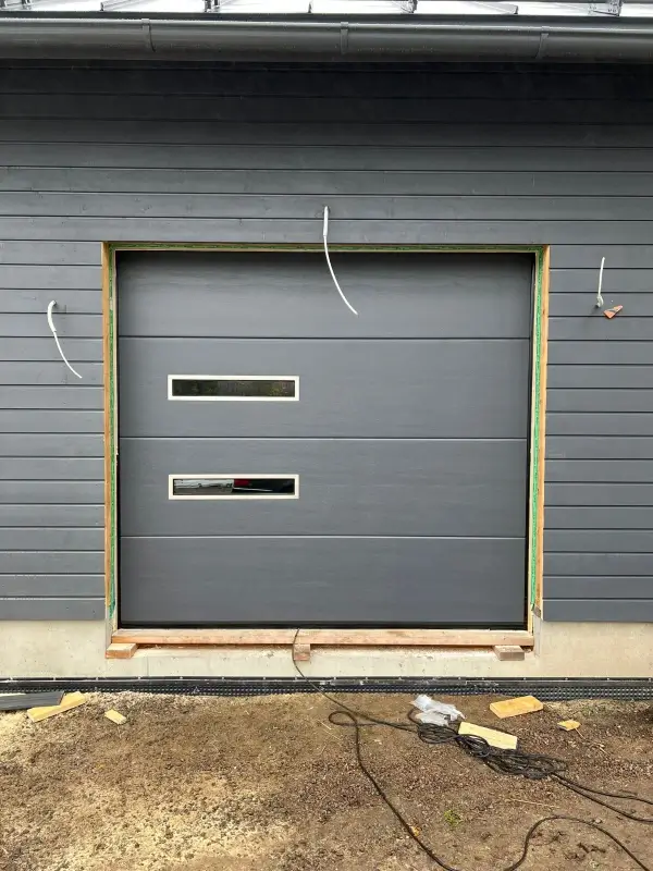 Yhtenäinen sileä nosto-ovi design-ikkunoilla Haminassa — JK-Ovet